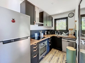 A compact kitchen with a refrigerator, microwave, oven, and sink. - Villa lake view, pets welcome - 6 guests (Soustons)