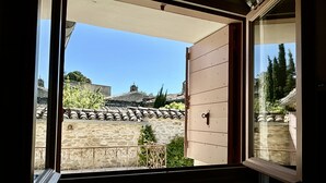 Ein Balkon mit Steinmauer, Metallgeländer und Blick auf traditionelle Gebäude.