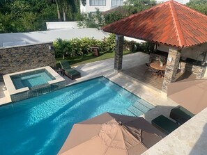 A swimming pool with a hot tub, lounge chairs, and a covered patio area. - All inclusive paid at the resort  (Puerto Plata)
