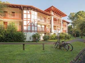 Ein mehrstöckiges Gebäude im traditionellen Baustil, mit Balkonen und einem zentralen Innenhof mit Fahrrädern.