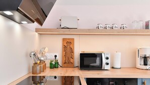 Une cuisine moderne équipée d’un four à micro-ondes, d’un grille-pain et d’une machine à café.