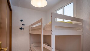 A bunk bed room with a window, a door, and a light fixture. - Seafront apartment, Wi-Fi included (Torredembarra)