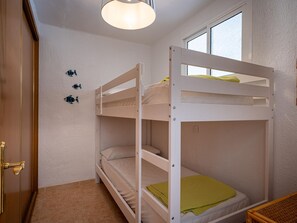 A bunk bed room with a window, a door, and a light fixture. - Seafront apartment, Wi-Fi included (Torredembarra)