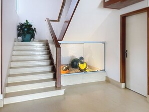 Eine Treppe mit einem hölzernen Geländer, die zu einer Zwischenebene führt.