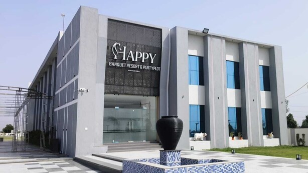 Un edificio moderno con un letrero que dice 'Happy Banquet Resort & Party Plot'.