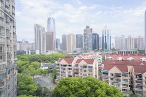 Un paisaje urbano con edificios altos, una combinación de estructuras residenciales y comerciales, y una calle bordeada de árboles.