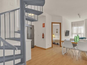 Ein modernes Interieur mit Treppe, Küche, Essbereich und Schlafzimmer.