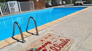 A swimming pool with a tiled area featuring a message in French. - Family mobile home - 6 guests (Rocamadour)