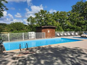 A swimming pool with a wooden structure, white fencing, and lounge chairs. - Mobile home with terrace - 2 guests (Rocamadour)