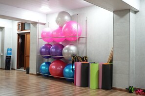 Un gimnasio con equipo de ejercicios, incluyendo rodillos de espuma y pelotas de pilates.