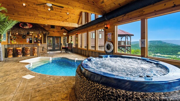 Ein Holzinnenraum mit Whirlpool, Pool und Bergblick.