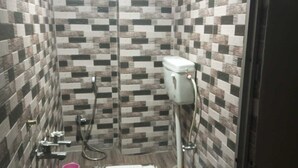 Un baño pequeño con azulejos, un inodoro, un bidé y un cubo.