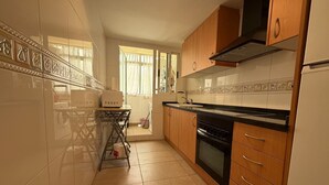 Cozinha com micro-ondas, forno e armários de madeira.