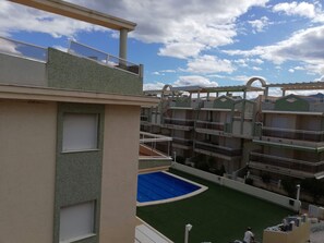 A multi-level building with balconies, a pool area, and a view of the sky. - Delfines III bl.IV esc.3 2º Solo Familias! (Playa Xeraco)