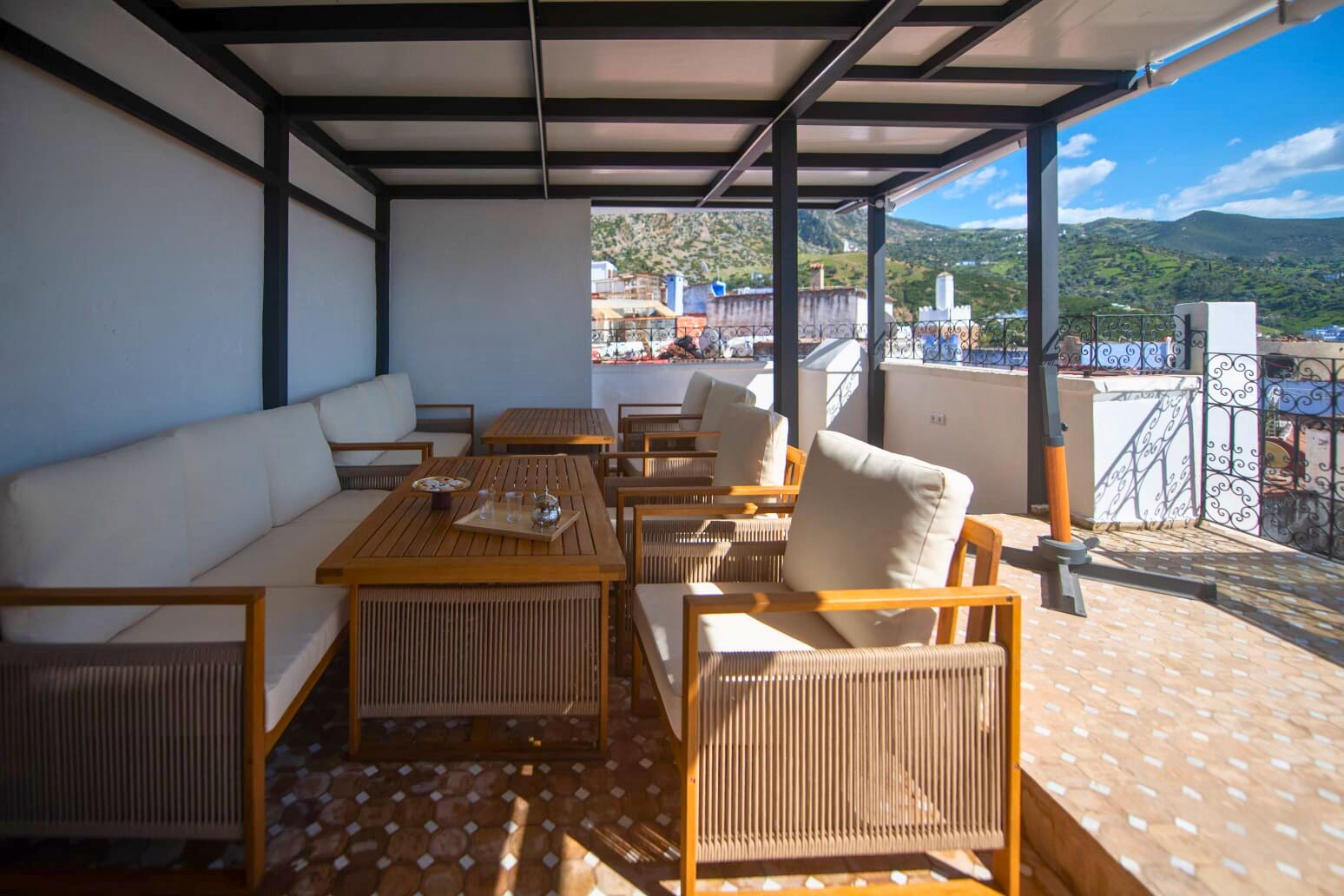 An outdoor seating area with wicker furniture and a view of the countryside.