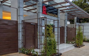 Ein Hotel Eingang mit einem Metallgitter, einem Schild mit der Aufschrift 'RIRARAOE' und einem Schild mit der Aufschrift 'LATTICE SECURITY'.