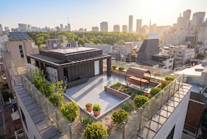 Une terrasse sur le toit au design moderne, dotée de panneaux solaires et agrémentée de plantes en pot.