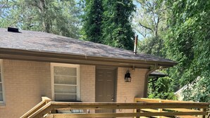 A wooden deck leading to a house with a brick exterior and a door. - Welcome to Sandtown Villa—your home away from home. (Atlanta)