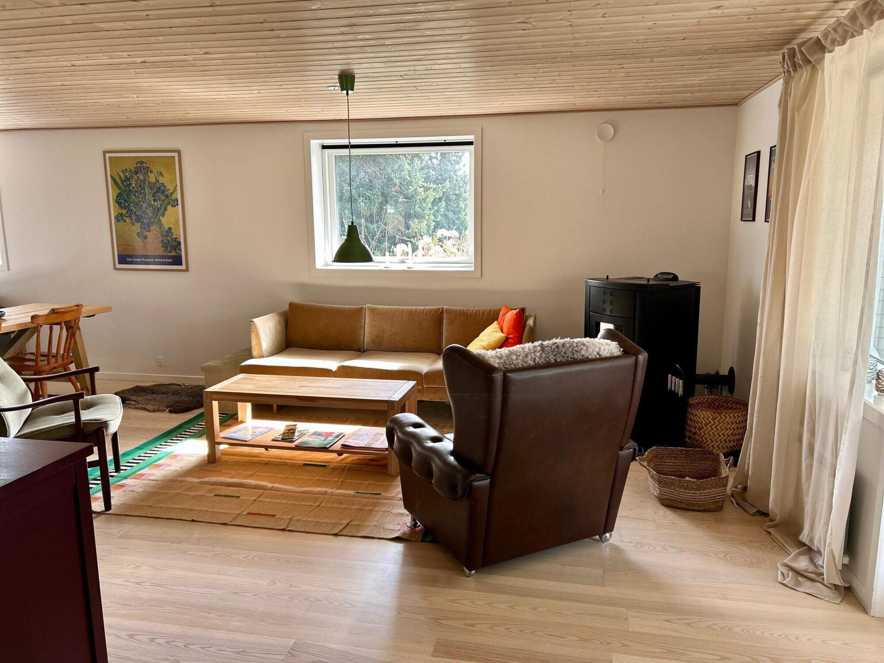 Un salon comprenant un canapé, un fauteuil, une table basse et un téléviseur.