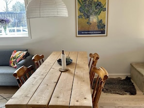 A wooden dining table with chairs, a vase, and a candle holder. - 4 Star Holiday Home in Oro (Orø)