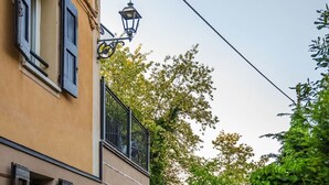 A narrow street with a building featuring a balcony, a street lamp, and a fence. - [Centro Storico] A/C, Terrazzo privato, WiFi (Fiorano Modenese)
