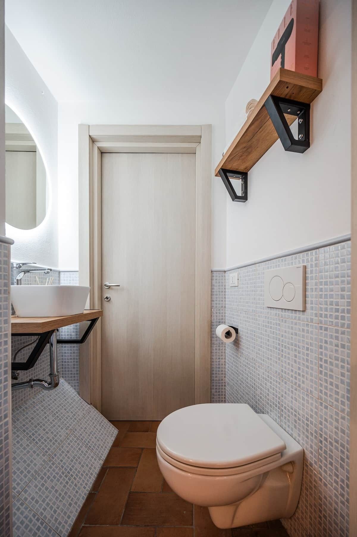 Ein Badezimmer mit Toilette, Waschbecken und Spiegel.