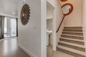 A modern interior with a staircase, a decorative wall piece, and a view to the outside. - The Lofts #17 Townhome Pool Resort, Poolside and Hot tub (St. George)
