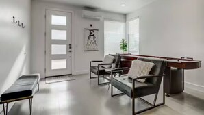 A modern living room with a pool table, comfortable seating, a door with frosted glass panels, and an eye chart on the wall. - The Lofts #17 Townhome Pool Resort, Poolside and Hot tub (St. George)