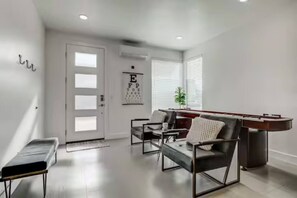 A modern living room with a pool table, comfortable seating, a door with frosted glass panels, and an eye chart on the wall. - The Lofts #17 Townhome Pool Resort, Poolside and Hot tub (St. George)