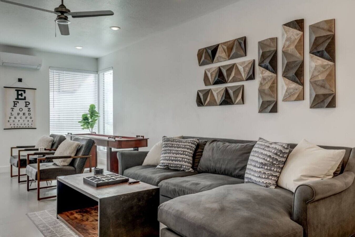A modern living room with a gray sofa, a coffee table, and a wall-mounted TV.