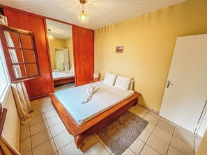 Ein Hotelzimmer mit Bett, Tür, Spiegel und Fenster.