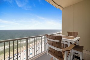 Ein Balkon mit Blick auf Strand und Meer.
