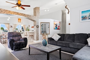 A modern living room with a sofa, armchair, and a coffee table. - Lake Serenity Retreat Private Pool, Lake Views, Game Room & Outdoor TV (Kissimmee)