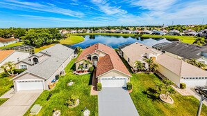 A residential area with houses, a swimming pool, and a clear sky. - Lake Serenity Retreat Private Pool, Lake Views, Game Room & Outdoor TV (Kissimmee)