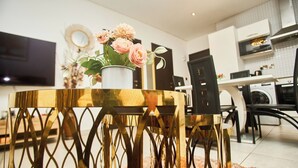 A modern kitchen with a dining area, a TV, and a washing machine. - Cozy 1-bedroom apartment in SIGNATURE (Accra)
