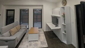 Moderni olohuone, jossa on sohva, sohvapöytä ja työpöytä.