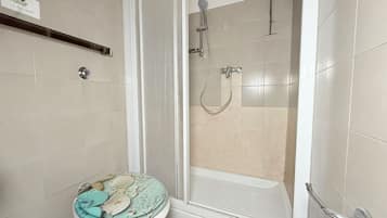 Un baño con inodoro, ducha y bañera.