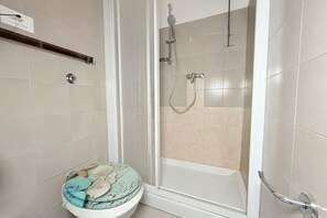 Ein Badezimmer mit Toilette, Dusche und Badewanne.