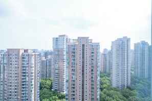 Edificios residenciales altos con múltiples balcones, rodeados de vegetación.