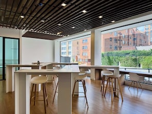 A modern office space with a large window, wooden ceiling, and a view of a brick building. - w Upscale Cozy Loft in the Heart of Bogot (Bogotá)