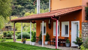 A house with a covered patio, outdoor seating, and potted plants. - Kalavrita Milodesi Country House Mountain Retreat (Kalavrita)