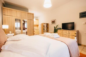 A hotel room with a bed, a television, a wardrobe, and a desk with a lamp. - Kalavrita Milodesi Country House Mountain Retreat (Kalavrita)
