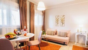 A modern living room with a sofa, dining table, and a small side table. - Kalavrita Milodesi Country House Mountain Retreat (Kalavrita)