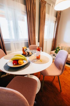 A dining area with a round table, chairs, a fruit bowl, a bottle, and a glass. - Kalavrita Milodesi Country House Mountain Retreat (Kalavrita)