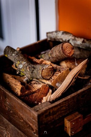 A wooden box filled with logs and wood shavings. - Kalavrita Milodesi Country House With Fireplace (Kalavrita)