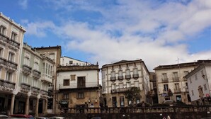 Una hilera de edificios históricos con balcones y cielo despejado.