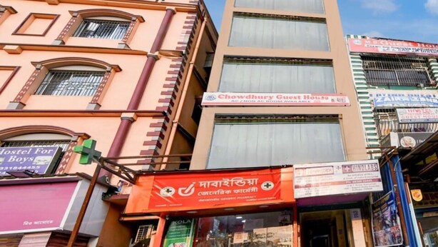 A multi-story building with various signs, including 'Chowdhury Guest House' and 'Kola' pharmacy. - Classic Chowdhury Guest House (Barakpur)