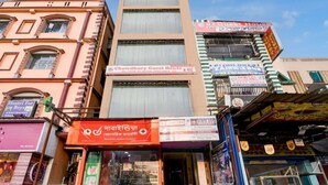 A multi-story building with various commercial establishments, including a guest house and a pharmacy. - Classic Chowdhury Guest House (Barakpur)