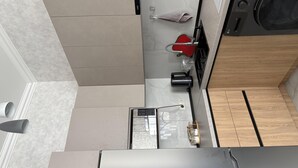 Eine moderne Küche mit integriertem Waschmaschine, Kaffeemaschine und Wasserkocher.