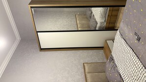 Ein Schlafzimmer mit einem Bett, einem Nachttisch und einem Spiegel.